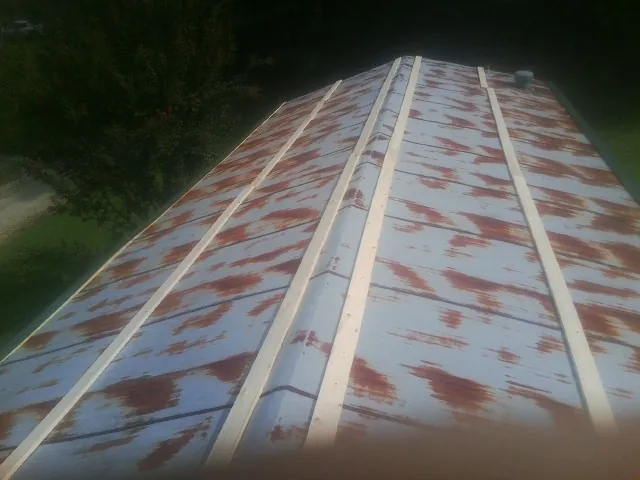 Rusted metal roof panels with new wood purlins before replacement — Storm Damage Roof Repair in Snellville by Roofing Brothers