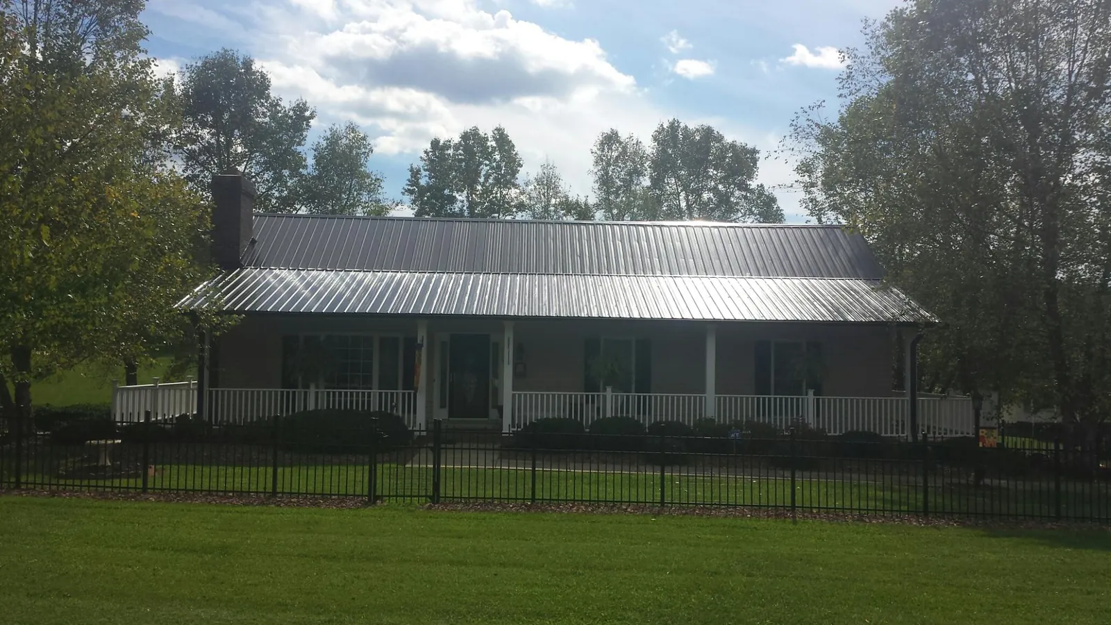 Gray metal roof on a brick ranch with a full width front porch — Gutter Guard Installation work by our crew in Snellville