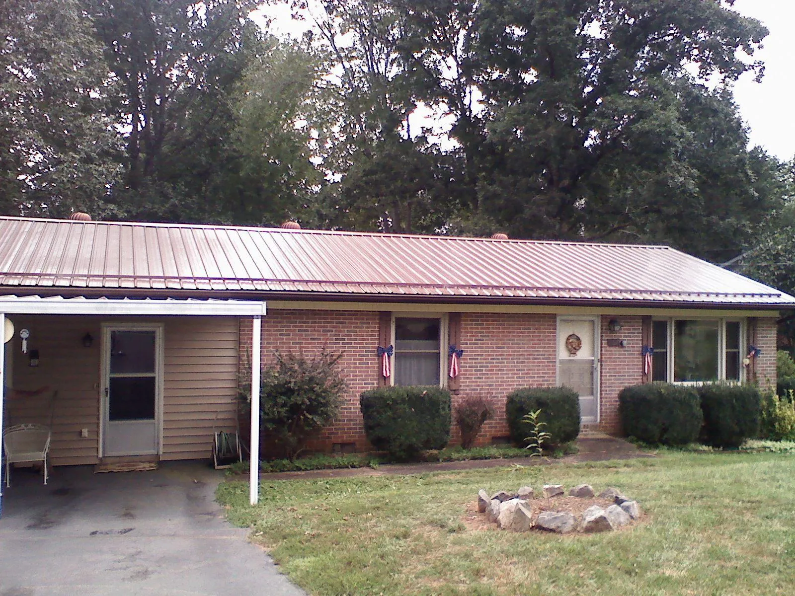 Bronze metal roof and carport on a brick ranch home — Roof Repair work by our crew in Snellville